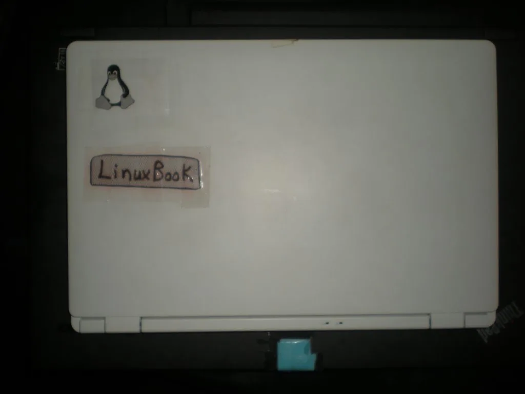 2014 LinuxBook and the little Tux logo. My 2014 LinuxBook, formerly known as Chromebook, displays its custom Tux logo and name. It's also sitting on top of my 2014 Lenovo ThinkPad W540 laptop.