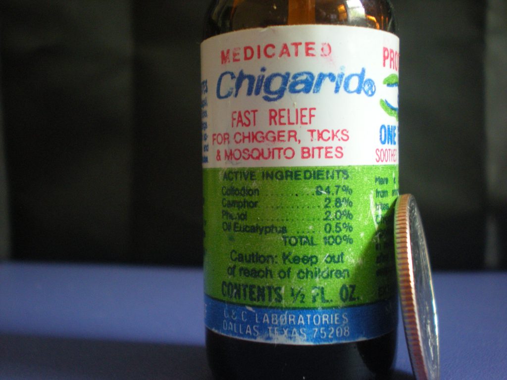 Image of half-ounce bottle of medicated chigarid® produced by C&C Laboratories of Dallas, Texas. A quarter coin is leaning against the bottle for size context.