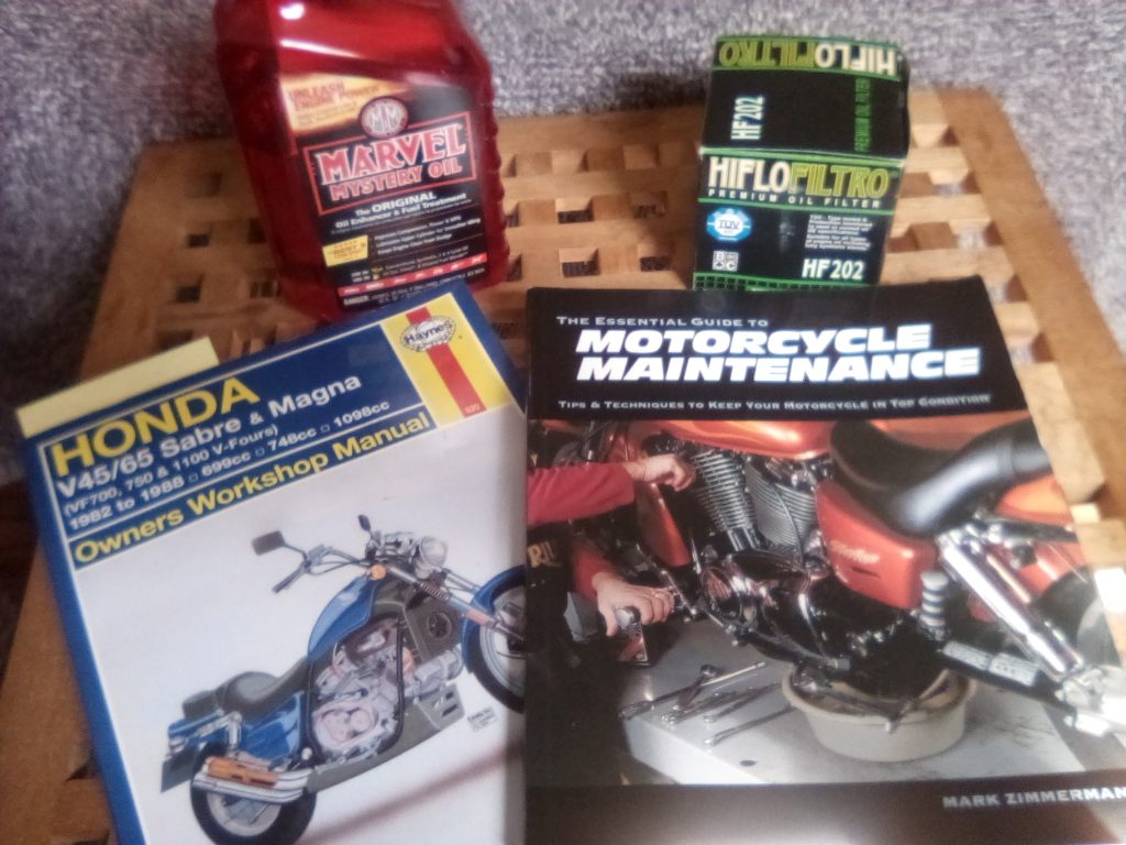 Image of Honda Magna v65 Manual, Marvel Mystery Oil, and a HiFlo HF202 oil filter.