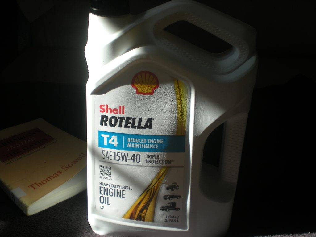 Pic of Shell Rotella T4 15W-40 Heavy Duty Diesel Engine Oil and, in the background, "Barbarians Inside the Gates," a book by Thomas Sowell.