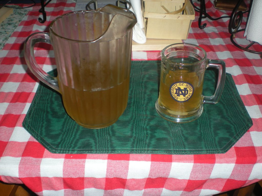 Homemade grapefruit-peppermint IPA-like beverage ready to imbibe. Homemade grapefruit-peppermint IPA-like beverage in a pitcher and a Notre Dame glass mug.
