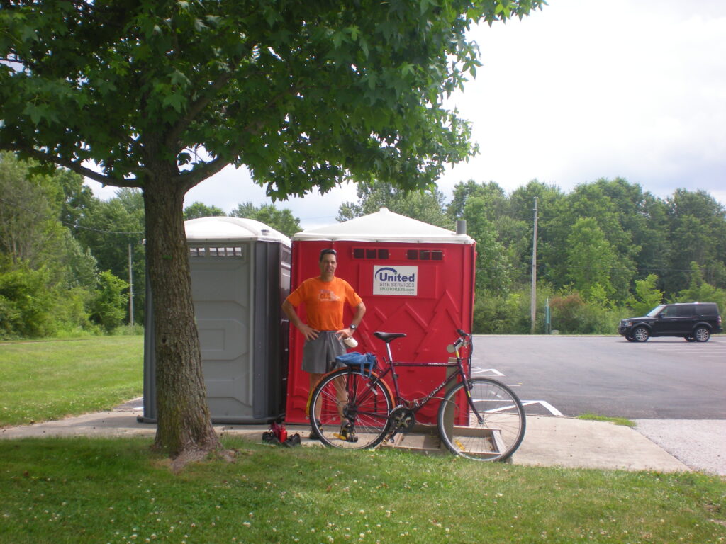 Joe at Sunside Trailhead | July 2025 Joe standing by the Porta-Potty and Cignal Rialto bicycle at Sunside Trailhead of Western Reserve Greenway Rail-Trail in Trumbull County Ohio MetroParks | July 2025