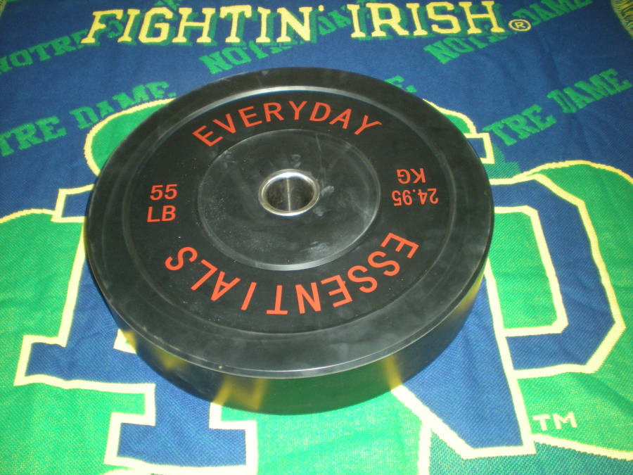 A 55-lb Everyday Essentials bumper plate on a Fightin' Irish of Notre Dame blanket.